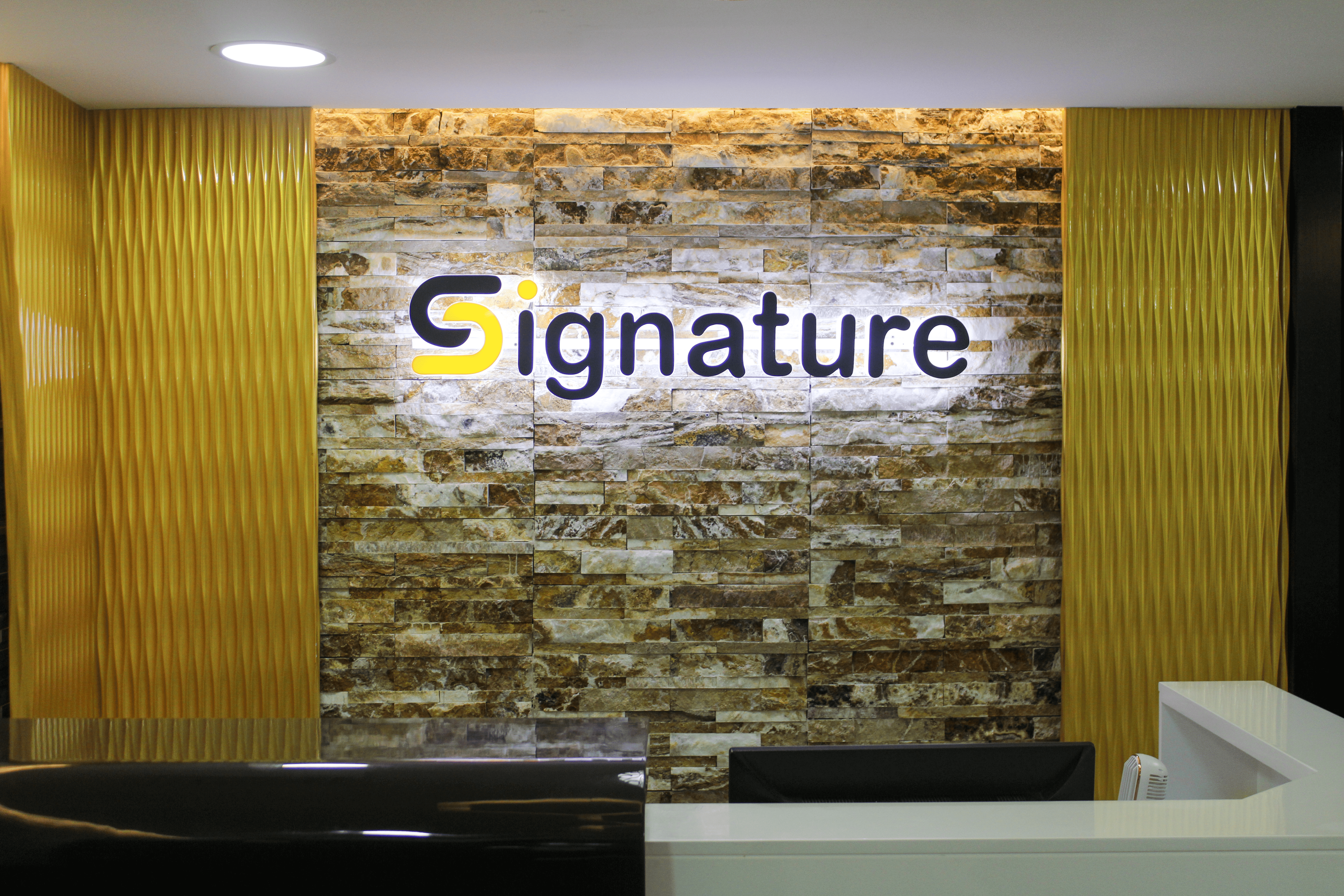 SIGNATURE office reception with branded stone feature wall